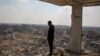 在以色列与哈马斯停火期间,一名巴勒斯坦男子在加沙地带南部拉法望向被摧毁的建筑物废墟。