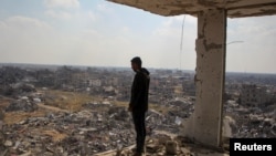 在以色列与哈马斯停火期间,一名巴勒斯坦男子在加沙地带南部拉法望向被摧毁的建筑物废墟。