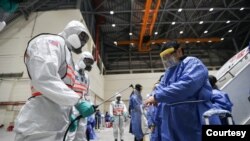 台湾防化兵在对从武汉飞抵桃园机场包机的台湾人进行防疫消毒作业。(台湾国防部军闻社提供)