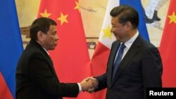 Tổng thống Philippines Rodrigo Duterte (trái) bắt tay Chủ tịch Trung Quốc Tập Cận Bình sau một lễ ký kết ở Bắc Kinh, Trung Quốc, 20/10/2016.