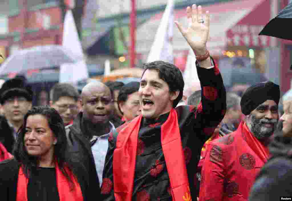 在加拿大温哥华的春节游行队伍中,加拿大总理特鲁多招手致意,他和国防部长(右)都穿唐装,左侧是女司法部长(2017年1月29日)。  