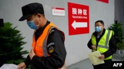 北京市朝阳区的居民在一处新冠病毒疫苗接种区排队等候接种。(2021年1月15日)