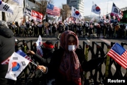韩国总统尹锡悦的支持者手持美韩国旗在首尔总统府附近举行示威反对弹劾总统。(2025年1月9日)