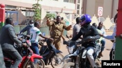 资料照片:一名布基纳法索军人请求聚集在军营外表示支持军队的人群散去。(2022年1月24日)