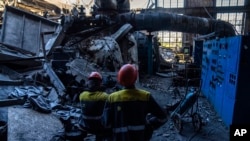 资料照:俄罗斯在乌克兰发动袭击后,工人们站在被俄罗斯袭击后DTEK火力发电厂的废墟中。(2024年5月2日)