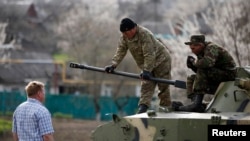 在乌克兰东部,乌克兰士兵站在坦克上与亲俄抗议者交谈(2014年4月16日)