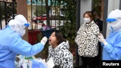 中国甘肃省兰州市的医护人员正在给居民进行新冠病毒核酸检测。(2021年10月20日)