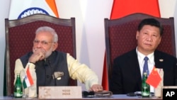 Індія, яка головує в ШОС, балансує між відносинами із Заходом, Росією і Китаєм, пише Reuters. На архівному фото - прем'єр-міністр Індії Нарендра Моді (л) і президент Китаю Сі Цзіньпін під час зустрічі лідерів БРІКС в Індії, 16 жовтня 2016 року. AP/Manish Swarup