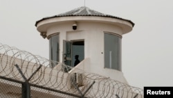 中国新疆喀什一名卫兵在拘留营的瞭望塔上站岗。(2021年5月3日)
