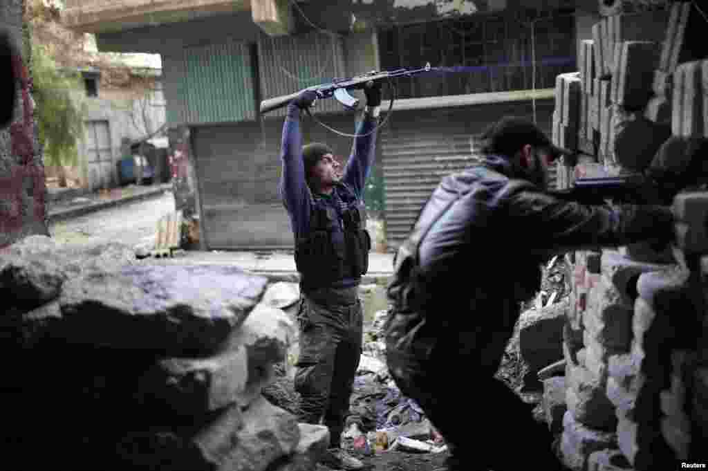 叙利亚自由军的战士12月24日在阿勒颇与忠于阿萨德总统的部队作战