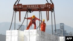 中国东部江苏省连云港市的港口,工人们将出口产品装船(2020年6月7日)。