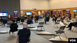 在联邦卫生当局宣布建议暂停接种强生新冠疫苗的一天前,人们在马里兰州在一家社区学院设置的大型新冠疫苗接种站接种强生疫苗后坐在观察区内。(2021年4月12日)