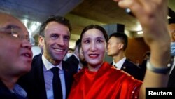 2023年4月5日,法国总统马克龙在中国北京红砖美术馆与参加活动者合影。(路透社照片)