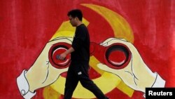 一名男子从上海街头中共党徽前走过。(2019年9月25日)