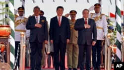 巴基斯坦新闻部发布的照片显示,中国主席习近平和巴基斯坦总统侯赛因(左)总理谢里夫(右)在伊斯兰堡的空军基地检阅仪仗队(2015年4月20日)