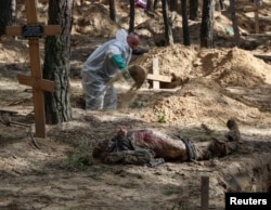 Місце масового поховання в Ізюмі, виявлені після звільнення ЗСУ від російських військ на Харківщині, 19 вересня 2022. REUTERS/Gleb Garanich