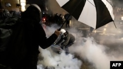 2021年4月12日,明尼苏达州明尼阿波利斯市布鲁克林中心,人们在布鲁克林中心警察局外,躲避警察的燃放催泪瓦斯。