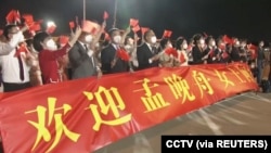 在广东深圳宝安国际机场打着横幅欢迎孟晚舟回国的人群。(2021年9月25日)