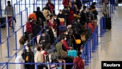 上海浦东国际机场内戴着口罩的旅客。(2020年1月27日)