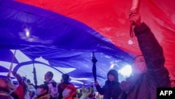 2023年12月23日,在台湾总统选举前的国民党竞选集会上,支持者举起巨大的台湾国旗。