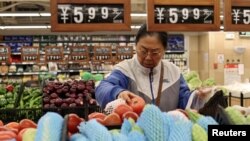 资料照片:一名顾客在北京一家超市购买蔬菜。(2024年10月17日)