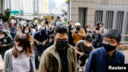 (自右至左)前香港众志秘书长黄之锋、主席林朗彦及成员周庭2020年11月23日到达西九龙裁判法院出庭受审(路透社)