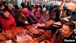 置办年货的北京市民在超市的腊肉腊肠摊位前选购。(2020年1月16日)