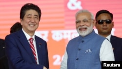 日本首相安倍晋三与印度总理莫迪在艾哈迈德巴德的高铁动工仪式上握手。(2017年9月14日)