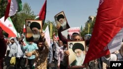 伊朗民众在首都德黑兰周五正午祈祷后举行的反以色列示威中挥舞着巴勒斯坦和伊朗的国旗。(资料照片:2024年4月19日)