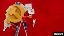 资料照:浙江省嘉兴南湖革命纪念馆的两名工人在墙上漆一面中共党旗。(路透社照片)