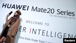 一名模特站在华为在英国伦敦发起的华为Mate20系列的广告牌前。(2018年10月16日)