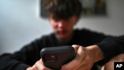 澳大利亚悉尼的一名少年在使用手机浏览社交平台。(2024年11月13日)