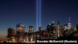 纽约曼哈顿下城远眺,两道蓝色光柱直射云霄,象征着20年前在恐怖袭击中倒塌的双子塔世贸大厦。(路透社/Brendan McDermid)