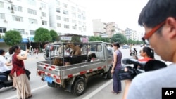 活动人士在玉林狗肉市场拦下一辆小卡车,谈判赎买价钱,以拯救即将被宰杀的狗。(2014年6月20日)