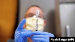 资料照片:加利福尼亚州萨克拉门托,一名药剂师在准备一剂辉瑞新冠疫苗时抽取生理盐水。(2021年1月12日)