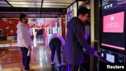 中国观影者在北京首都电影院的自助服务机上购买电影票。(2024年2月21日)