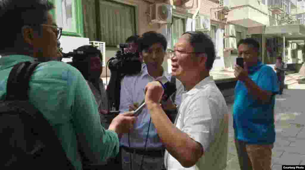 炎黄春秋杂志社负责人胡德华在被强占的办公地点外面接受外媒采访(2016年7月26日,网络图片)