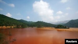 中国广东省北部大宝山附近呈棕红色的受污染湖泊。(资料照)