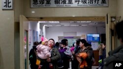 家长和孩子在北京儿童医院的候诊室等候。(2016年12月18日)
