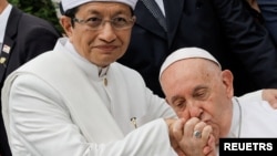 教宗方济各在印度尼西亚雅加达伊斯蒂克拉尔清真寺与宗教领袖举行宗教间会议后,亲吻伊斯提克拉尔清真寺大伊玛目纳萨鲁丁·乌马尔的手。(2024年9月5日)