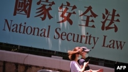 资料照:行人走过香港政府在香港街头竖立的宣传国家安全法的宣传牌。(2020年7月15日)