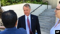 法庭为伊凯卡·康指定的辩护律师在法院外回答记者问题 (2017年7月10日)