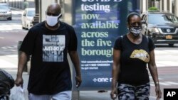 2020年5月15日冠状病毒大流行期间纽约戴防护口罩的行人。