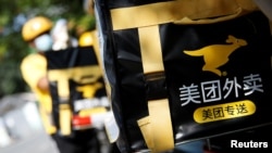 北京金融区的一个美团外送小哥骑着电摩在外送。(2020年7月15日)