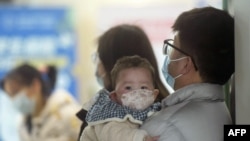 资料照片:中国杭州一家医院内等待就诊的一家人。(2025年1月6日)