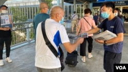 元朗区议员林进(右)及多名天水连线成员8月11日早上7时开始在天水围西铁站,免费向市民派发超过1千份《苹果日报》 (美国之音/汤惠芸)