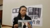 李明哲的妻子李净瑜向媒体展示李明哲以往活动的照片(美国之音杨明拍摄) 