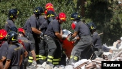 意大利救援人员从瓦砾堆中抬出一名地震遇难者。 (2016年8月25日)