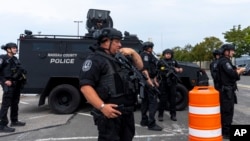 共和党总统候选人前总统唐纳德·特朗普2024年9月18日抵达纽约州联合戴尔拿骚体育馆参加竞选活动并发表讲话之前,拿骚县特警站在停车场。