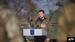 На фото пресслужби президента України Володимир Зеленський вшанує хвилиною мовчання пам’ять загиблих воїнів під час відвідування навчального центру у невстановленому місці в Україні. 3 листопада 2023 року.